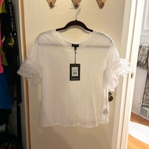 Boxy white T with sheer ruffle sleeve accents.